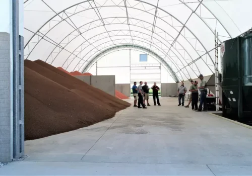 Grain is seen being stored in a fabric building. Greenfield Contractors offers grain storage.