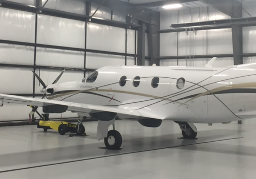 A small plane is seen in a storage facility. Greenfield Contractors constructs storage buildings for transportation.